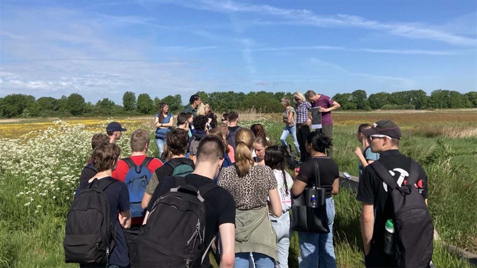 Met een groep scholieren het groene veld in.
