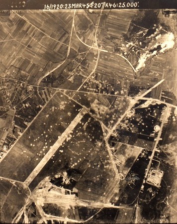 Oude luchtfoto in zwartwit van het gebombardeerde vliegveld. De bommen zijn witte stipjes in het landschap