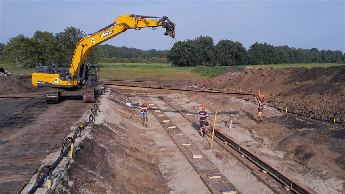 In de afgegraven bouwkuip wordt een rails van stalen profielen aangelegd. Hierover kan de duiker onder de N371 worden geduwd.