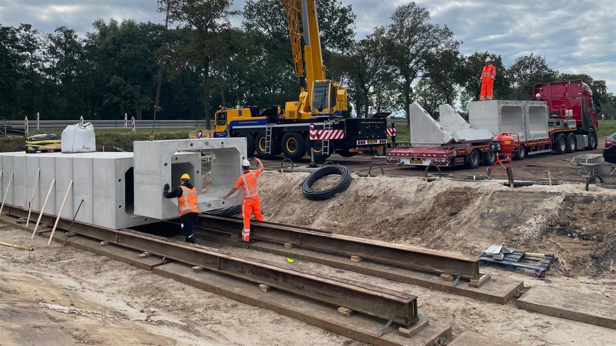 Zodra de rails klaarligt, worden de duikerelementen stuk voor stuk erop gezet.